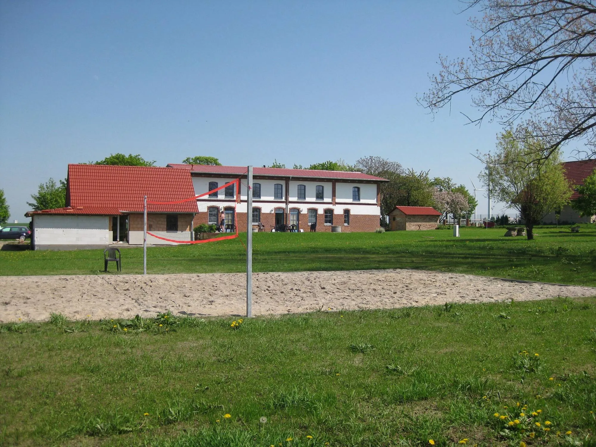 Sandplatz mit Volleyballnetz auf der Wiese vor den Ferienwohnungen